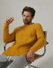Model wearing knitted ribbed yellow sweater and grey joggers